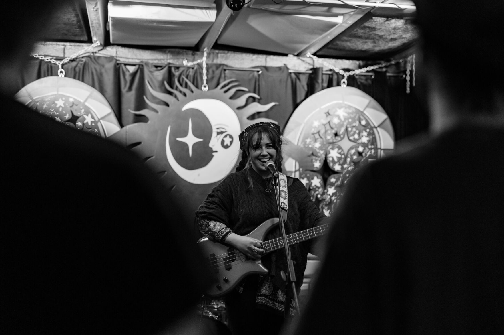 Sofie Pedersen with a guitar onstage at drkmttr, framed by two audience members